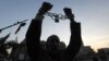 A man holds up his chained hands as he protests against Egypt's President Mohamed Morsi at Tahrir Square in Cairo, Egypt, December 18, 2012.