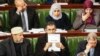 A member of Tunisia's parliament holds up a copy of a document that reads in Arabic "Draft Constitution of the Republic of Tunisia,"Jan. 3, 2014 in Tunis.