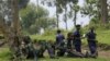 M23 rebel fighters watch the venue of a news conference by political leader Jean-Marie Runiga, in Bunagana, eastern DRC, in north Kivu province, July 21, 2012.
