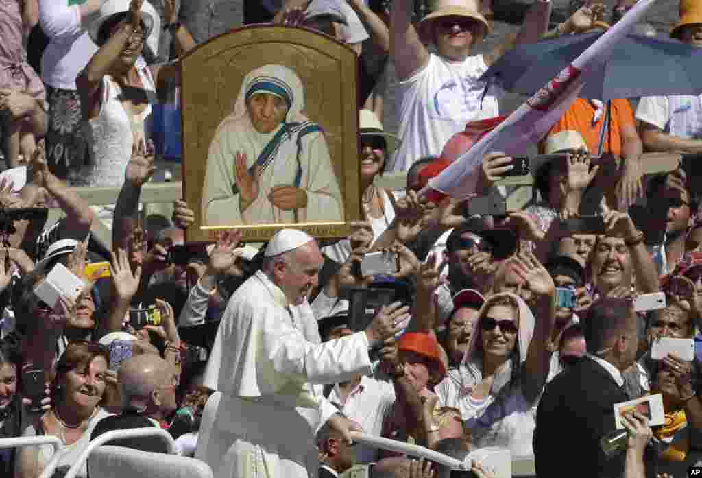 Pope Francis passes in front a portrait of Mother Teresa as he is driven through the crowd at the end of a canonization ceremony in St. Peter's Square at the Vatican, Sept. 4, 2016.