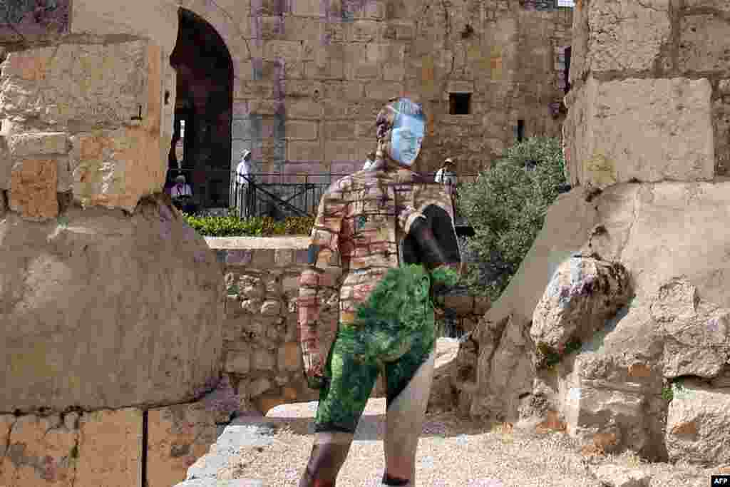 A male model painted by 31-year-old Israeli artist Avi Ram poses for a picture at the Tower of David in Jerusalem's Old City .