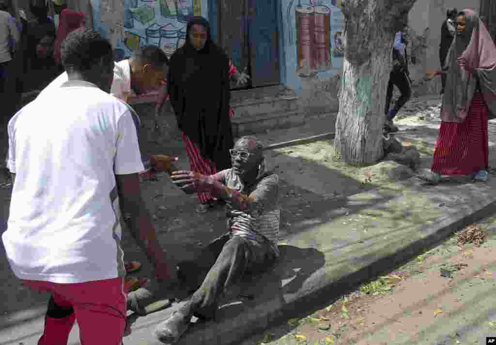 A wounded man reaches out to rescuers after a car bomb attack in Mogadishu, Somalia. A suicide car bomber detonated near the Weheliye hotel in the capital, killing a number of people on the busy Maka Almukarramah road, police said.