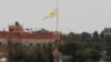 FILE - In this photo taken from the Turkish side of the border between Turkey and Syria, in Akcakale, southeastern Turkey, a flag of the Kurdish People's Protection Units, or YPG, flies over the town of Tal Abyad, Syria, June 16, 2015. 