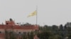 FILE - In this photo taken from the Turkish side of the border between Turkey and Syria, in Akcakale, southeastern Turkey, a flag of the Kurdish People's Protection Units, or YPG, flies over the town of Tal Abyad, Syria, June 16, 2015. 