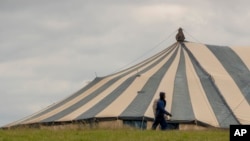 FILE - A man carrying a bag walks past a large unoccupied church marquee after Easter Weekend celebrations were cancelled due to lockdown to prevent the spread of coronavirus, at Katlehong near Johannesburg, South Africa, April 10, 2020, 