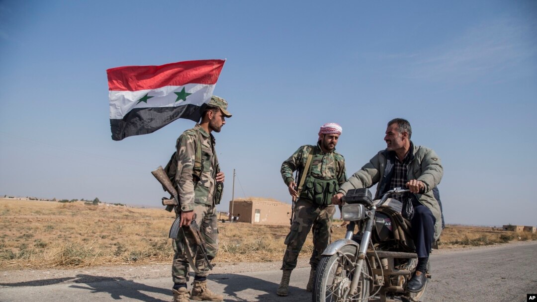 Syrian government forces man a checkpoint near the town of Tal Tamr, north Syria, Oct. 22, 2019. 