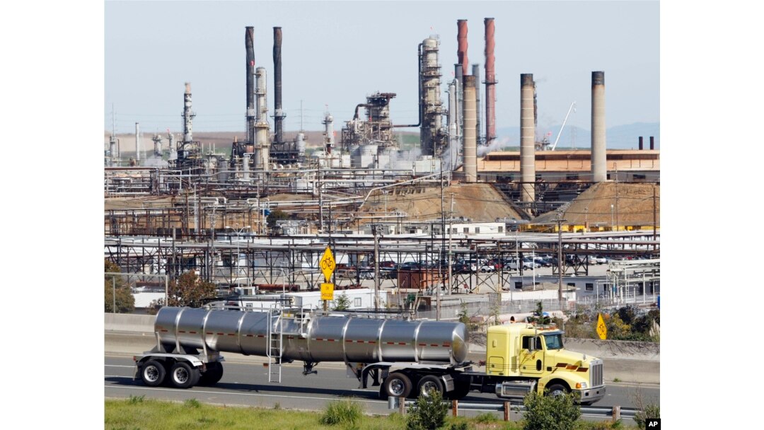 FILE - A tanker truck passes the Chevron oil refinery in Richmond, Calif.