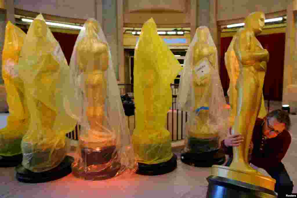 Workers carry a large Oscar statue up the red carpet as preparations continue for the 89th Academy Awards in Hollywood, Los Angeles, California. The awards will be handed out Sunday.