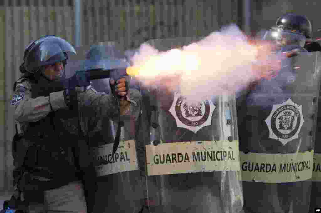 A municipal guard fires tear gas at demonstrators during a protest against the state government in Rio de Janeiro, Brazil, Feb. 20, 2017. The protesters denounced a proposal to privatize the state's water and sewage company.