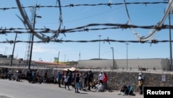 Migrants gather along the U.S. Mexico border near El Paso before the lifting of Tile 42