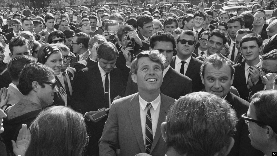 FILE - In this June 7, 1966, file photo Sen. Robert F. Kennedy is surrounded by students and newsmen as he tours Stellenbosch, South Africa, during a five-day visit to South Africa as the guest of the multiracial National Union of South African students.