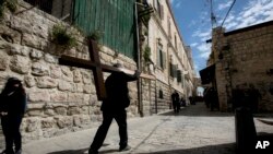 Un hombre carga una cruz durante la procesión del Viernes Santo en la ciudad vieja de Jerusalén.