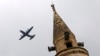 With a mosque's minaret in the foreground, a United States Air Force cargo plane takes off from Incirlik Air Base, on the outskirts of the city of Adana, southern Turkey, July 30, 2015. 