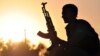 FILE - A fighter from the Kurdish People Protection Unit (YPG) poses for a photo at sunset in the Syrian town of Ain Issi, some 50 kilometres north of Raqqa, uring clashes between IS group jihadists and YPG fighters on July 10, 2015. 