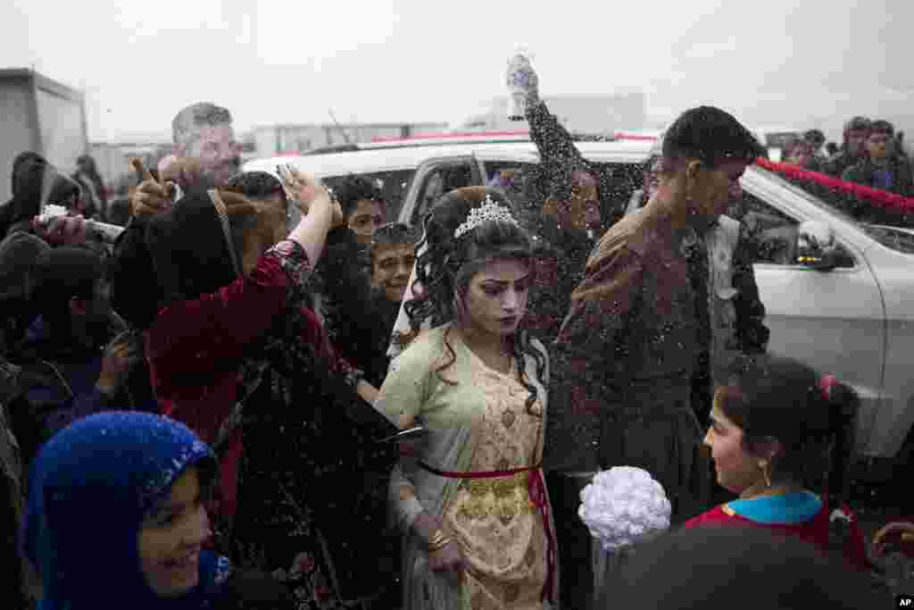 Hussein Zeino Danoon and Shahad Ahmed Abed arrive at the Khazer camp for people displaced from Mosul for their wedding. It's the second marriage to take place in the IDP camps east of the city where tens of thousands are living, having fled the fighting in Mosul, Iraq.