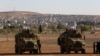 FILE - Turkish soldiers take up position a few hundreds meters from the border with Syria not far from the Syrian Kurd city of Kobani, from their vantage point near Suruc, Turkey, Oct. 4, 2014.