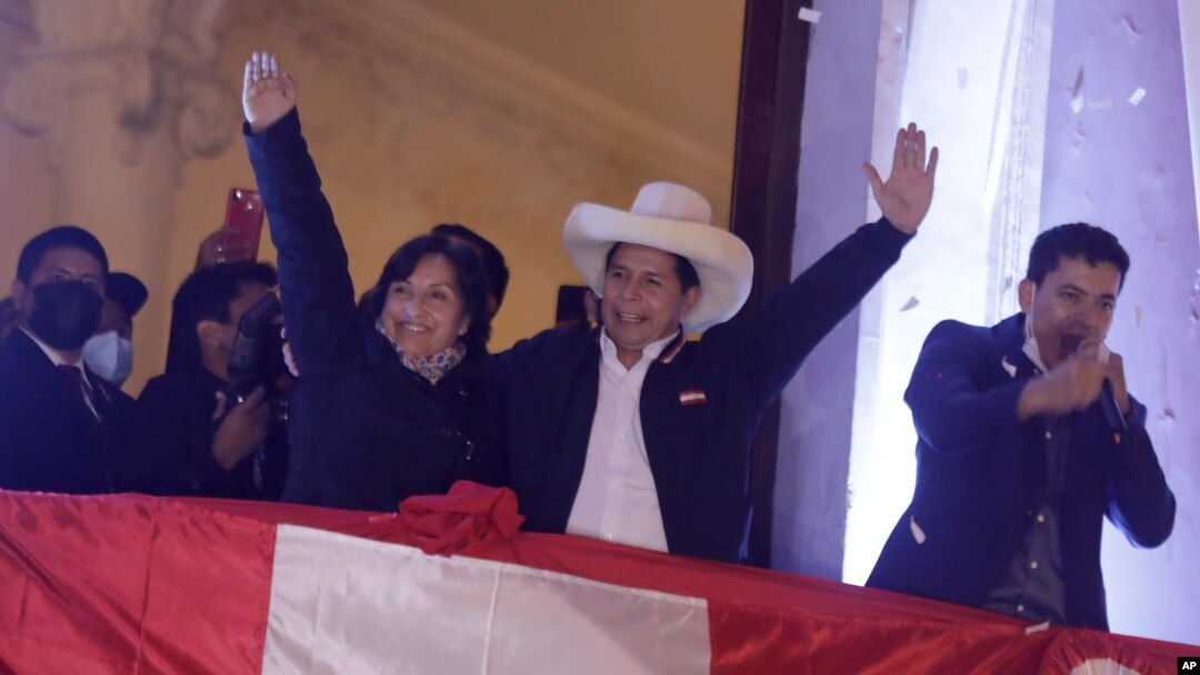 Pedro Castillo, center, celebrates with his running mate Dina Boluarte after being declared president-elect of Peru by election authorities, at his party´s campaign headquarters in Lima Peru, July 19, 2021. 