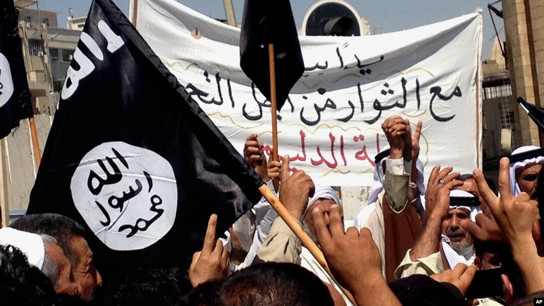 FILE - Demonstrators chant pro-al-Qaida-inspired Islamic State of Iraq and the Levant (ISIL) statements as they wave al-Qaida flags in front of the provincial government headquarters in Mosul, Iraq.