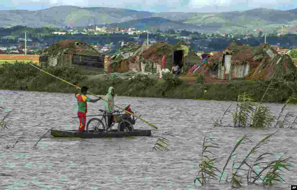 Residents cross flooded fields in Madagascar's capital Antananarivo. Officials say the death toll from Cyclone Enawo has risen to at least five and about 10,000 people have left their homes because of storm damage.