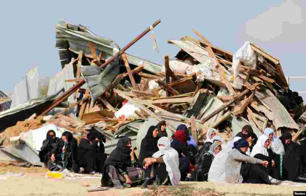 Arab Israeli women sit next to the ruins of their dwellings which were demolished by Israeli bulldozers in Umm Al-Hiran, a Bedouin village in Israel's southern Negev Desert.