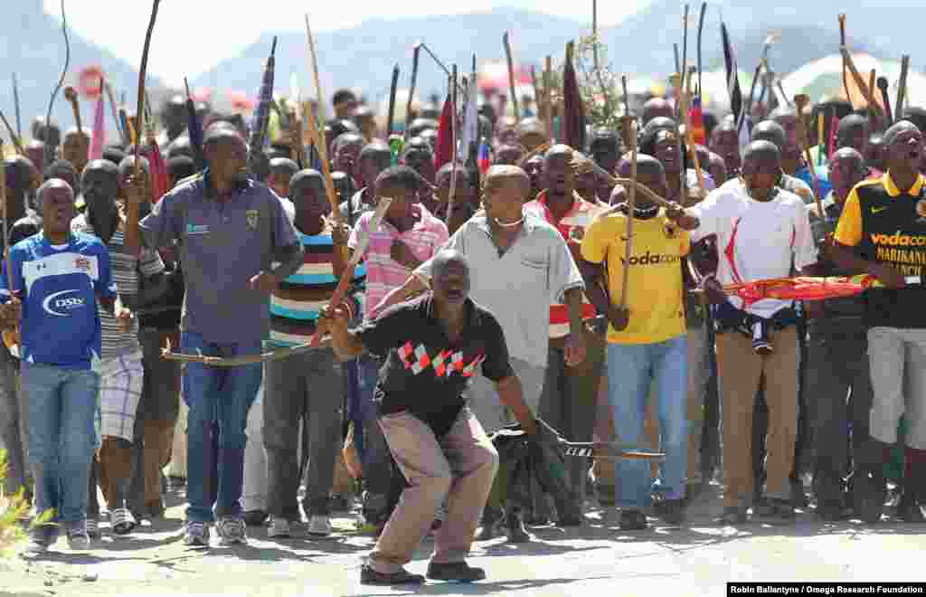 Miners sing and dance as they march to Lonmin Platinum Mine near Rustenburg, South Africa, Sept. 10, 2012, in an attempt to stop operations.