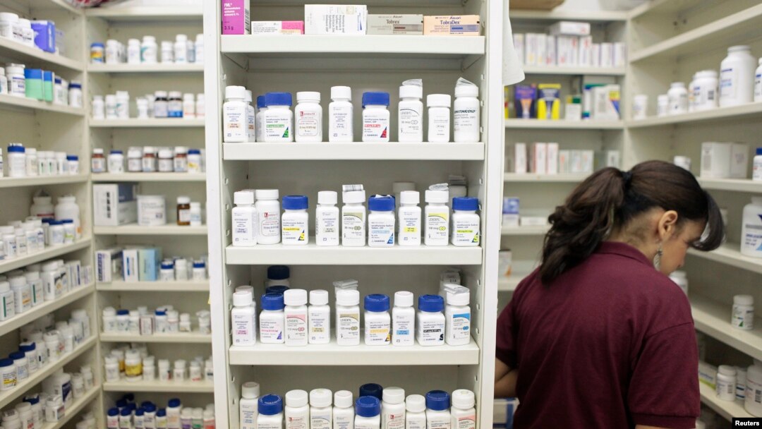 FILE - A pharmacy employee looks for medication as she works to fill a prescription while working at a drugstore in New York.