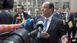 French President Francois Hollande gestures as he speaks to reporters upon his arrival for an EU summit, at the European Council building in Brussels, May 23, 2012.