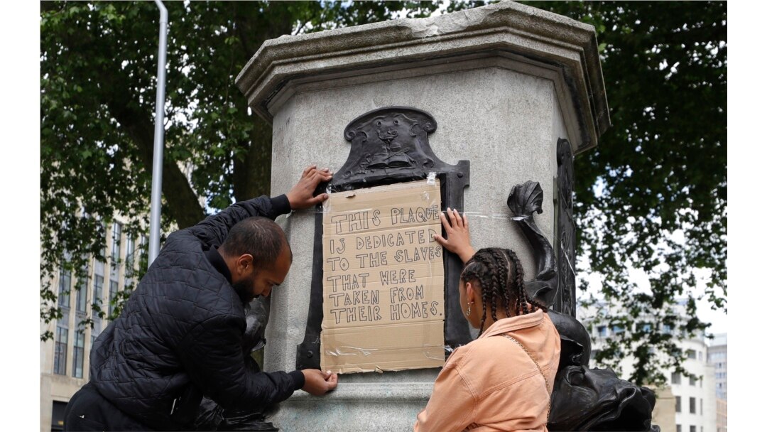 A banner is taped over the inscription on the pedestal of the toppled statue of Edward Colston in Bristol, England, June 8, 2020.