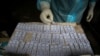 A health worker performs tests after taking nasal swab samples to test for COVID-19 in Gauhati, India, Aug. 7, 2020.