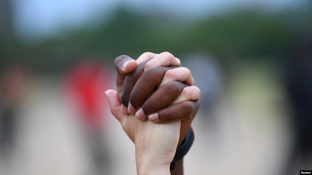 A man and a woman hold hands aloft in Hyde Park during a "Black Lives Matter" protest following the death of George Floyd who died in police custody in Minneapolis, London, Britain, June 3, 2020. 