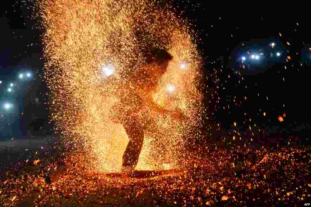 This picture shows a Pa Then ethnic dancer removing burning ashes during a fire dance at a local spring festival in Lam Binh district, northern province of Tuyen Quang, Vietnam.