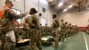 FILE - In this image provided by the U.S. Army, recent basic combat training graduates have their temperatures taken as they arrive at Fort Lee, Va, on March 31, 2020, after being transported using sterilized buses from Fort Jackson, S.C.