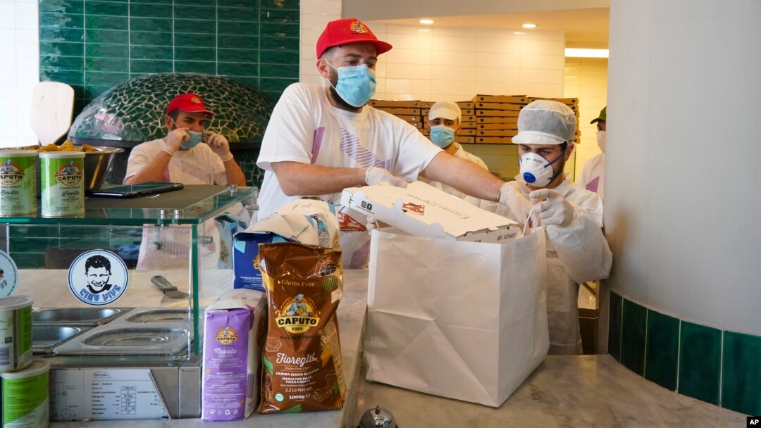 Pizzas are being prepared for home delivery at the Caputo pizzeria in Naples, Monday, April 27, 2020. Region Campania allowed cafes and pizzerias to reopen for delivery Monday, after a long precautionary closure due to the coronavirus outbreak. (AP Photo/Andrew Medichini)