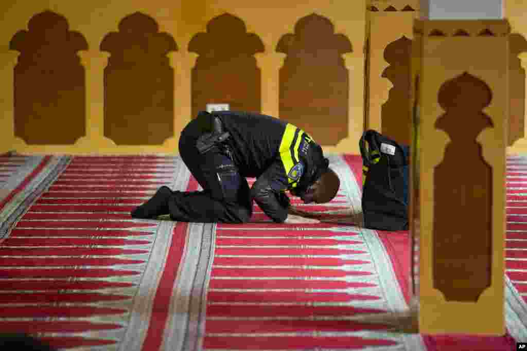 A Dutch police officer prays at the Al Kabir mosque in Amsterdam, Netherlands, where a meeting took place to show solidarity with Muslims, and protest against racism and discrimination.