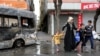 FILE - A woman with children walks by a vehicle, which was damaged during the clashes between security forces and Kurdish militants, in Baglar district, which is partially under curfew, in the Kurdish-dominated southeastern city of Diyarbakir, Turkey, March 15, 2016.