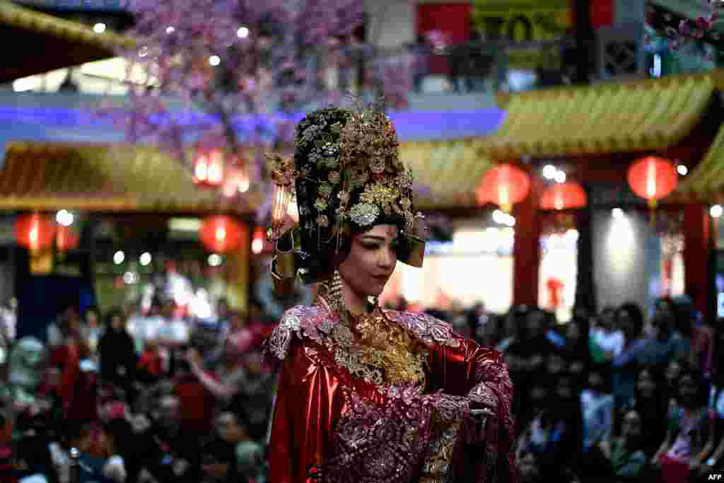 A performer dressed as Empress Huang of the China's Forbidden City takes part in a musical performance at a shopping mall in Kuala Lumpur to celebrate the upcoming Lunar New Year.