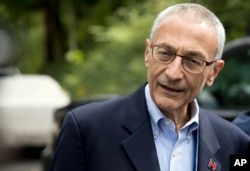 FILE - John Podesta, then Hillary Clinton's presidential campaign chairman, speaks to members of the media outside Clinton's home in Washington, Oct. 5, 2016.