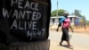 A woman walks past a message of peace in Kibera slum in the capital Nairobi, February 28, 2013.