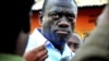 Kizza Besigye speaks to journalists, May 19, 2011, in the yard outside his house shortly after returning home after a confrontation with police, in Kasangati, Uganda. 