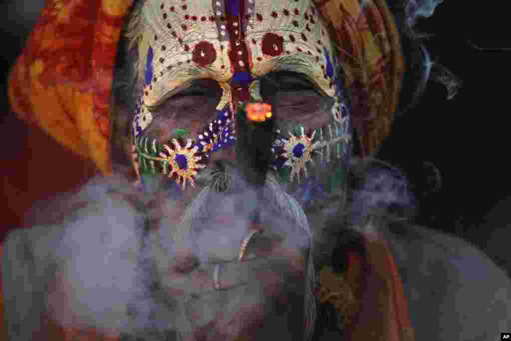 A Hindu holy man smokes marijuana at the courtyard of the Pashupatinath temple during Shivaratri festival in Kathmandu, Nepal. Shivaratri, or the night of Shiva, is dedicated to the worship of Lord Shiva, the Hindu god of death and destruction.