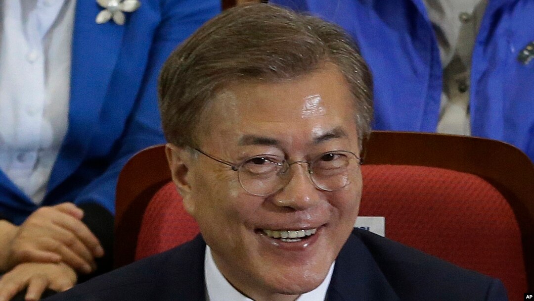 Moon Jae-in of the Democratic Party smiles as and leaders and members of the party watch local broadcast media's results of exit polls in the presidential election in Seoul, South Korea, May 9, 2017.