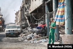 A medic takes a break outside a makeshift hospital near a battle zone in one of Mosul's many destroyed neighborhoods, July 5, 2017.