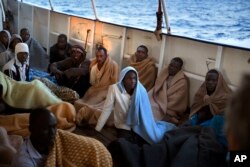 Men sit on the deck of the Golfo Azzurro rescue vessel after being rescued by members of the Spanish ONG Open Arms on the Mediterranean Sea, north of Zuwarah, Libya, June 21, 2017.