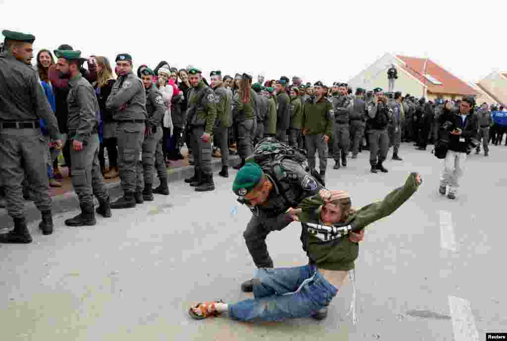 An Israeli border policeman removes a pro-settlement activist during an operation by Israeli forces to evict residents from several homes in the Israeli settlement of Ofra, in the occupied West Bank.