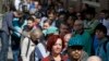 FILE - Job seekers line up in Denver, March 27, 2014.