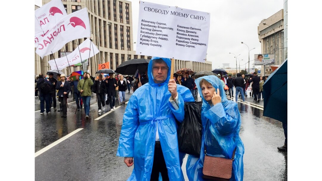 FILE - Vyacheslav Abanichev and Alisa Abanicheva, parents of Sergei Abanichev, hold a poster saying "Free My Son" with the names of all those arrested as they attend an opposition rally in Moscow, Russia, Aug. 10, 2019.