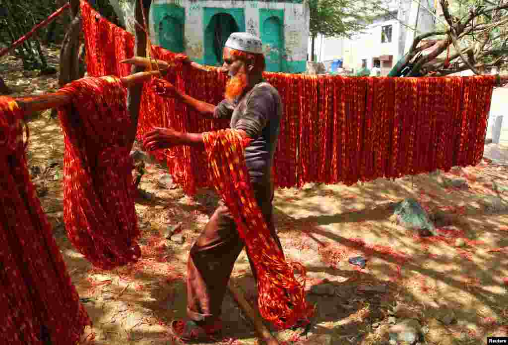 A worker hangs "Kalavas" or sacred threads to dry after dyeing them with colors in Ajmer, India.