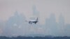 FILE - An Australian commercial aircraft prepares to land in the haze at Sydney's International Airport, July 15, 2014. 