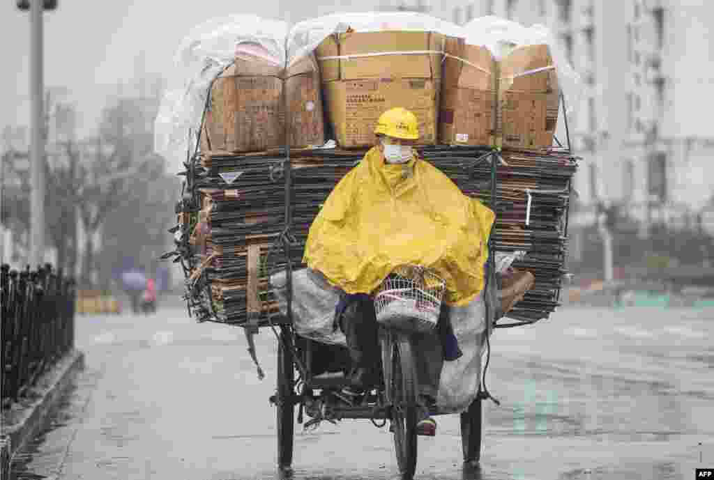 A worker steers his tricycle packed with recycling papers in Shanghai, China.