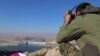FILE - A fighter from the Syrian Democratic Forces takes a position atop Mount Annan overlooking the Tishrin Dam, after they captured it from Islamic State militants, south of Kobani, Syria, Dec. 27, 2015.